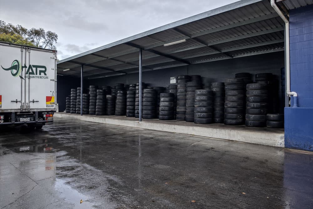 Commercial tyre storage area in wet winter conditions at a NSW workshop with covered staging and clear access